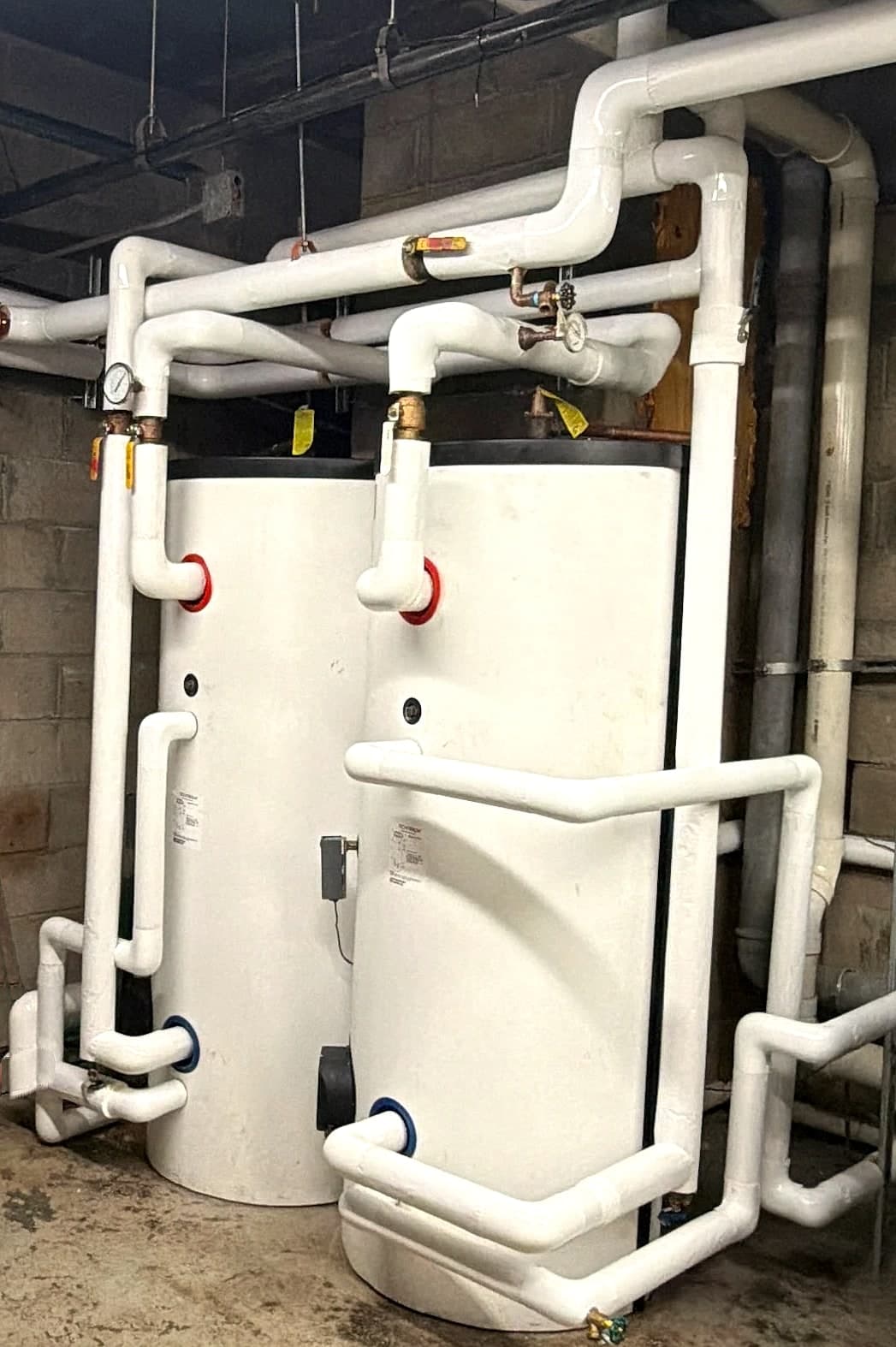 Two new HTP SuperStor Ultra 80-gallon indirect water heaters with insulated piping in a building mechanical room